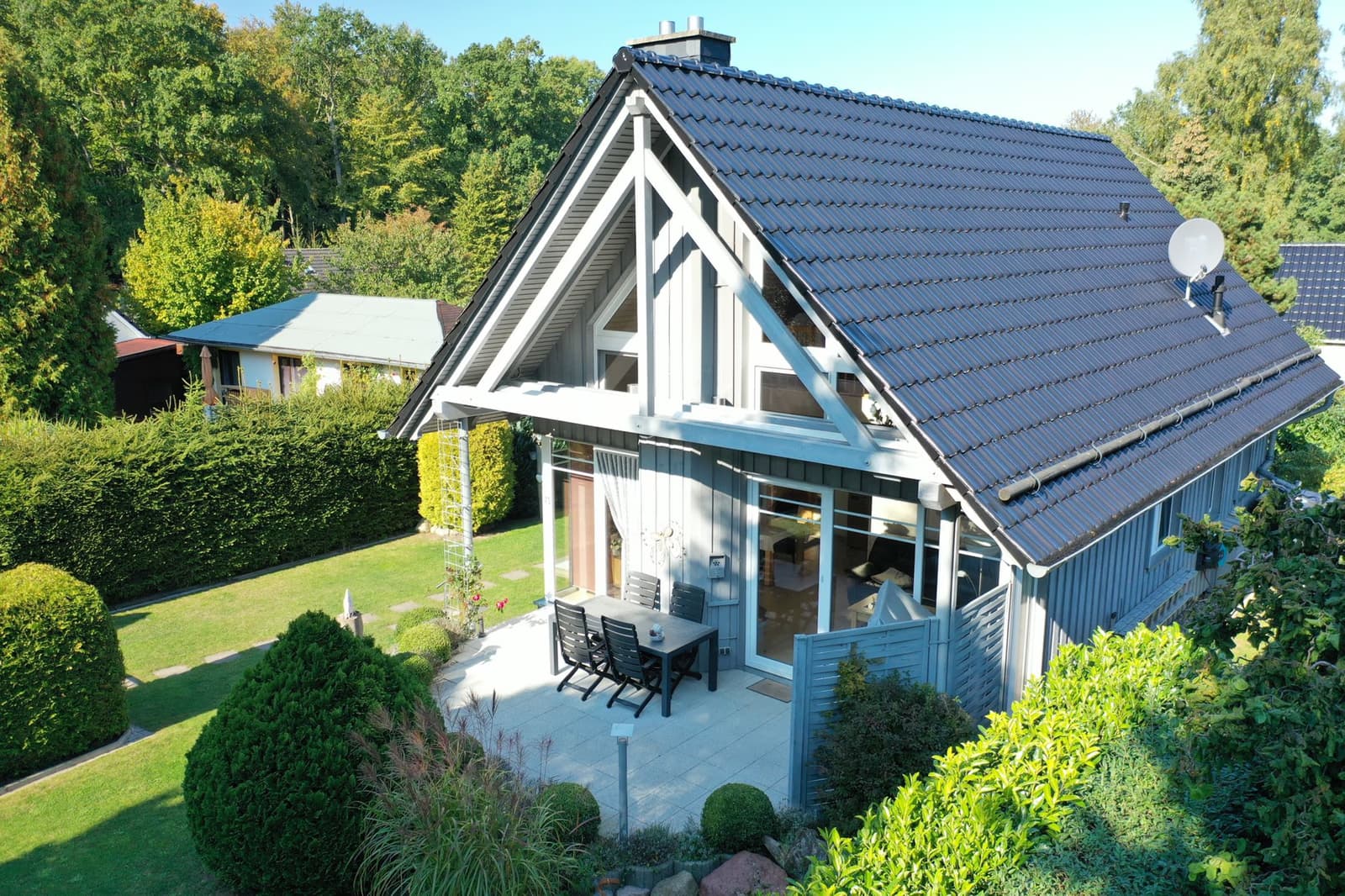 Südterrasse mit Sitzgruppe von oben, ringsum Garten und Hecken