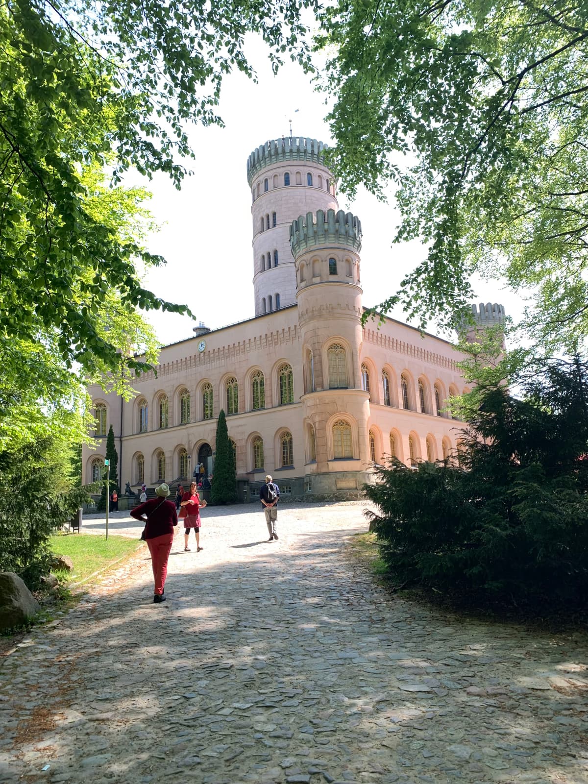 Jagdschloss Granitz mit seinem Turm, davor der gepflasterte Weg durch den Wald
